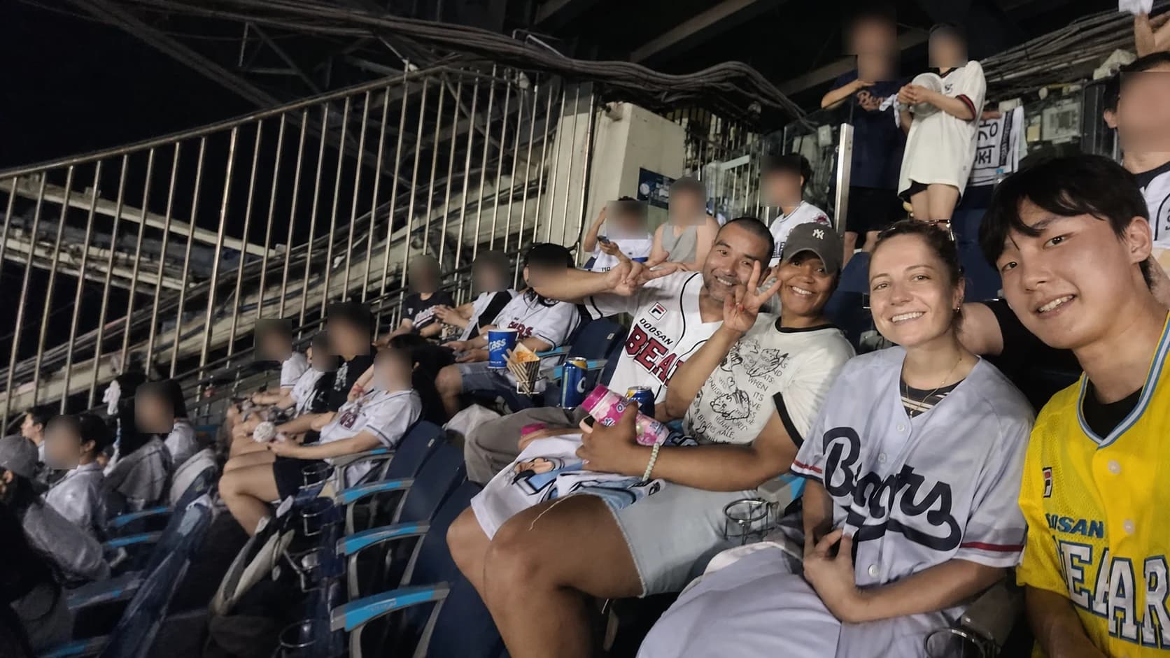 Travelers and local buddies cheering together at a baseball game