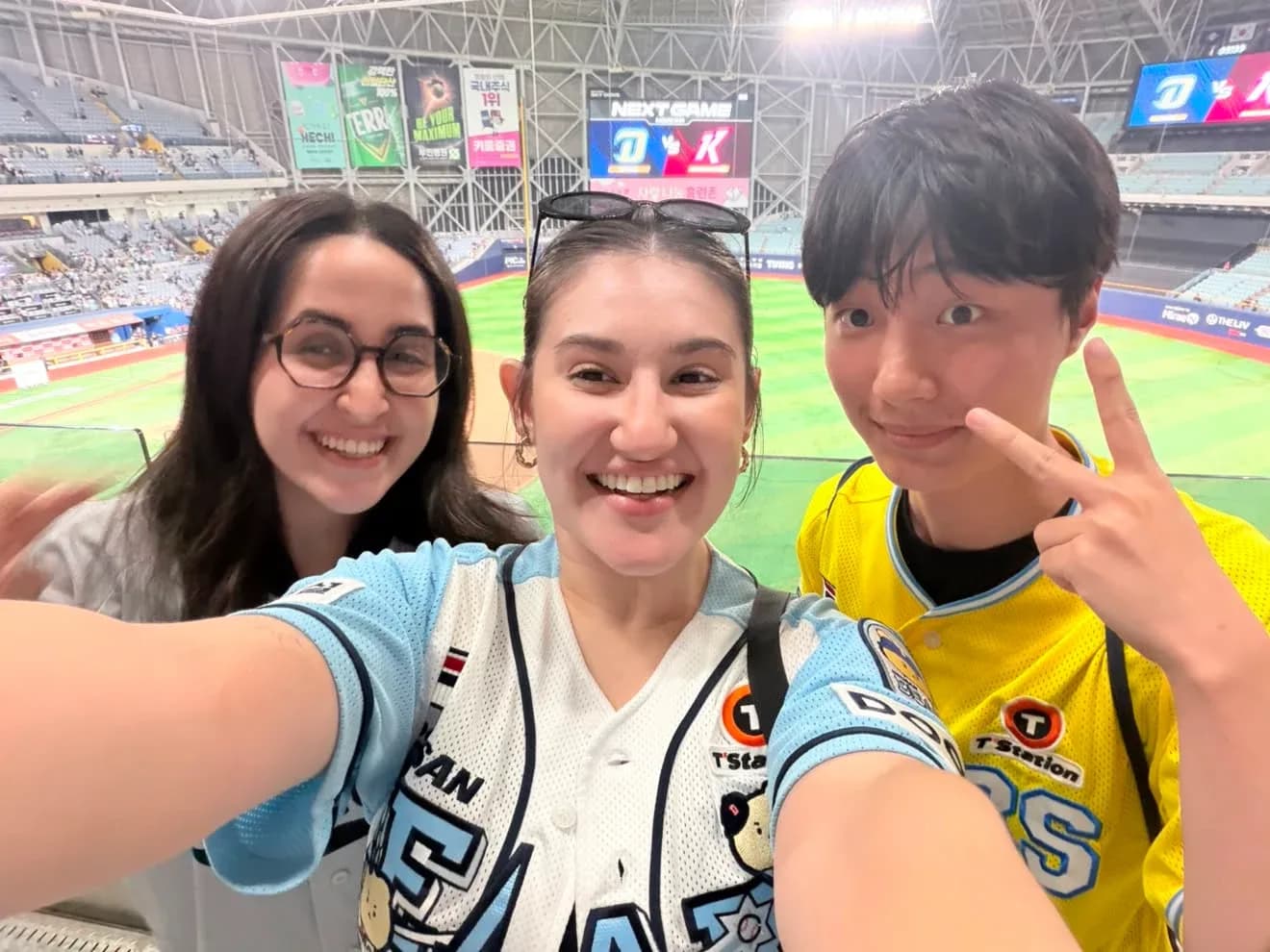 高尺スカイドームの観客席で笑顔の3人の友人